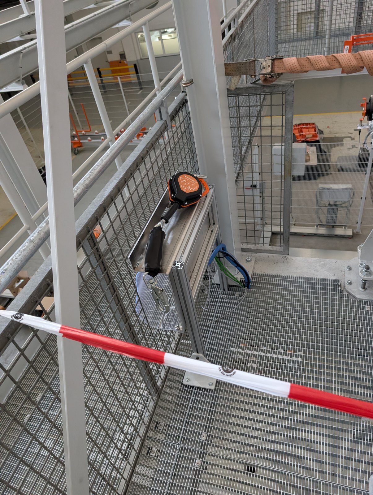 Gesicherter Gitterrost-Laufsteg mit Geländer in einer Industriehalle