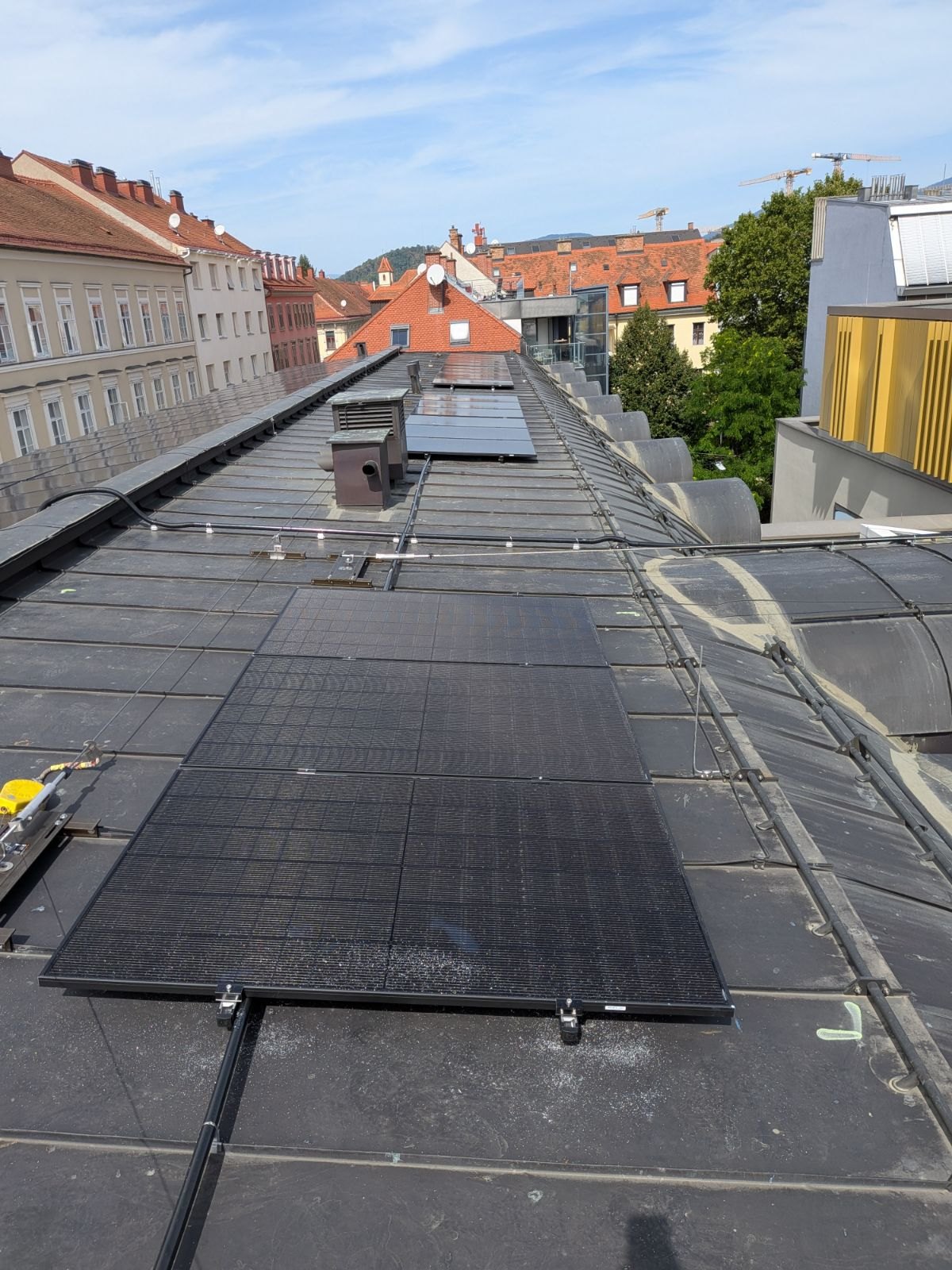 PV-Module auf einem langen Tonnendach im Grazer Stadtgebiet